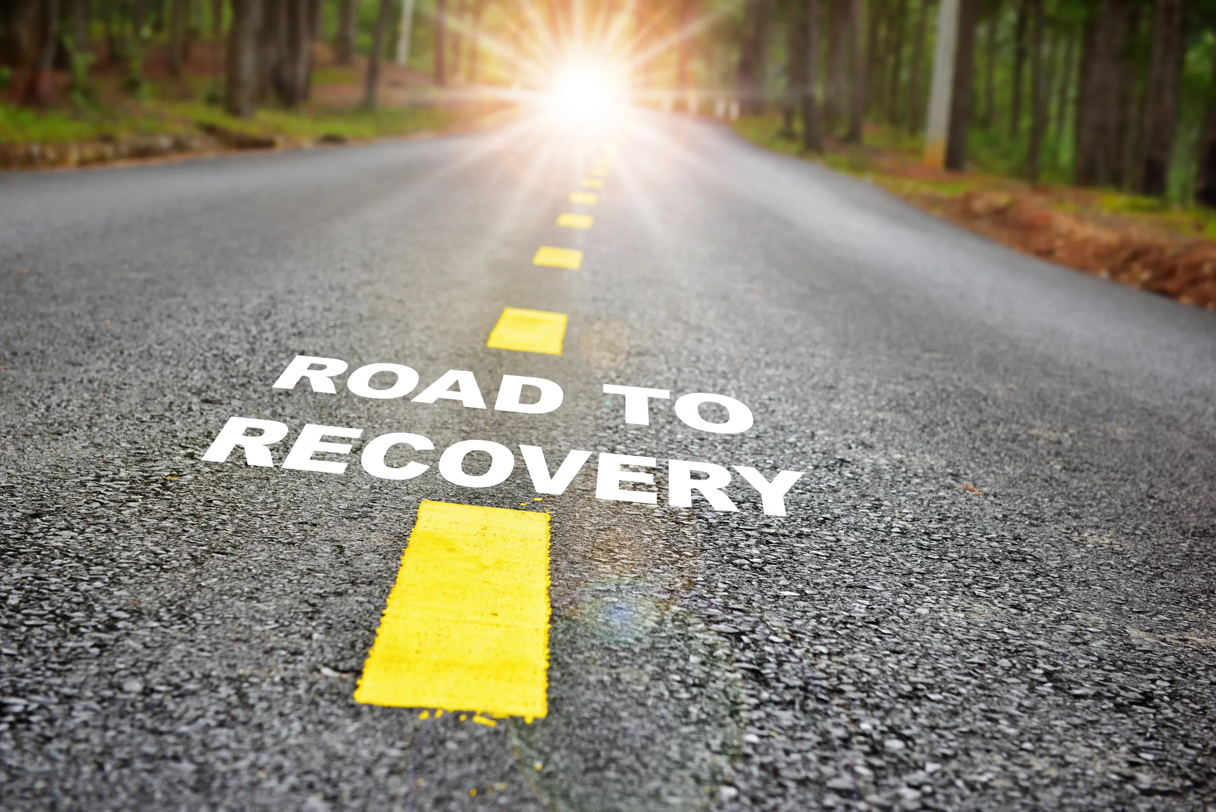 A road with the words ‘Road to Recovery’ painted on it